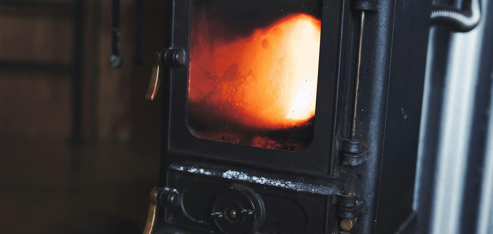 Flambée derrière la vitre d'un poêle en fonte, dans un intérieur