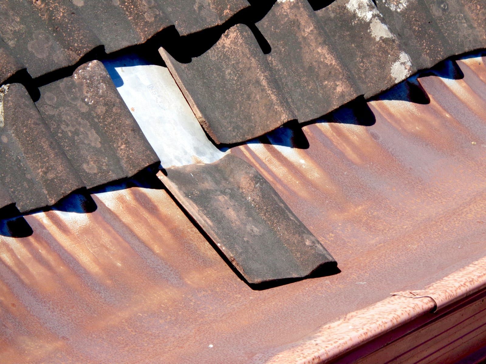 Tuile plate à remplacer sur une toiture ancienne